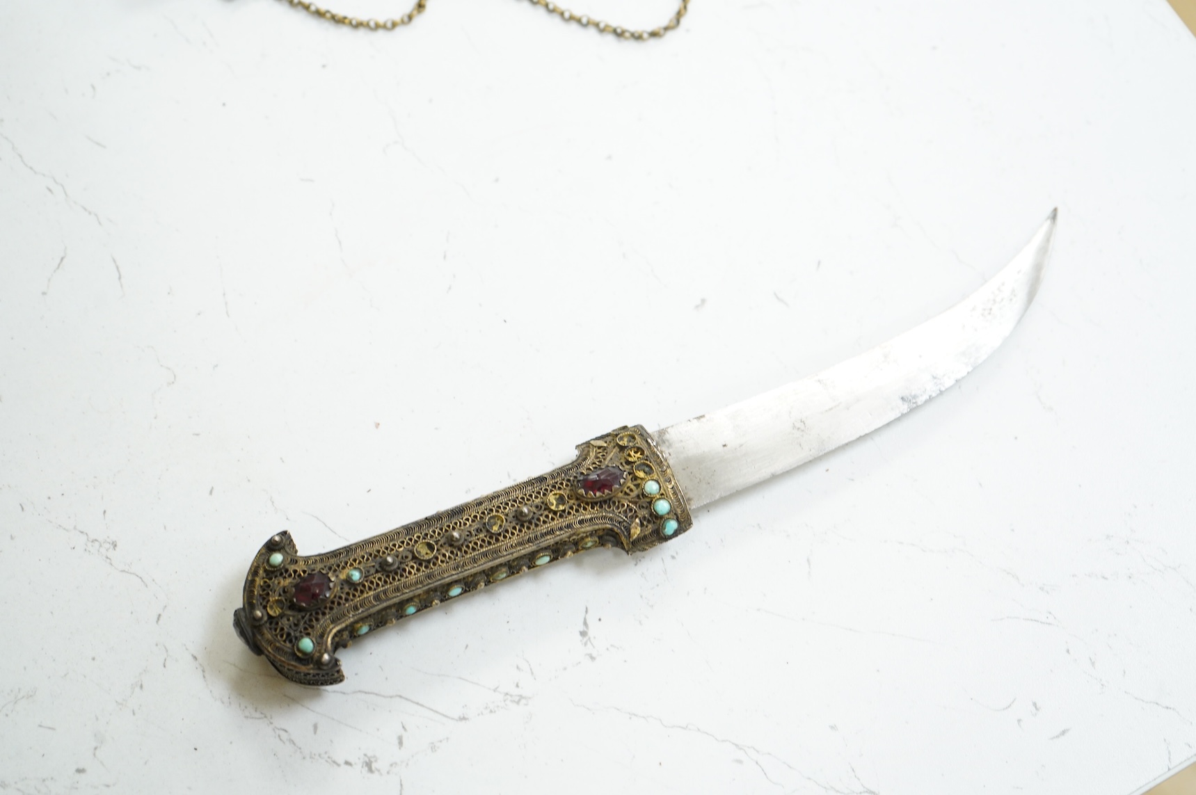 A Late 19th century Hungarian dagger, the hilt and sheath mounts made from filigree gilt silver wire applied with cabochon turquoise and red stones (some missing), blade 13.5cm